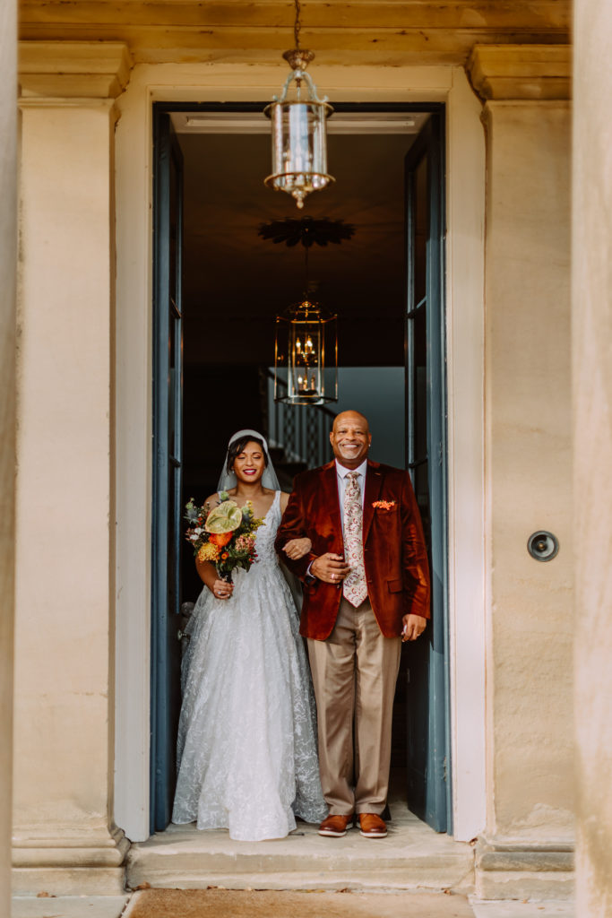Bride and her dad walking through the main entrance of Garthmyl Hall