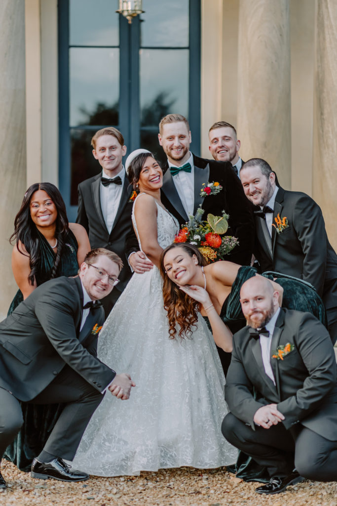 Bride and groom surrounded by bridal party smiling