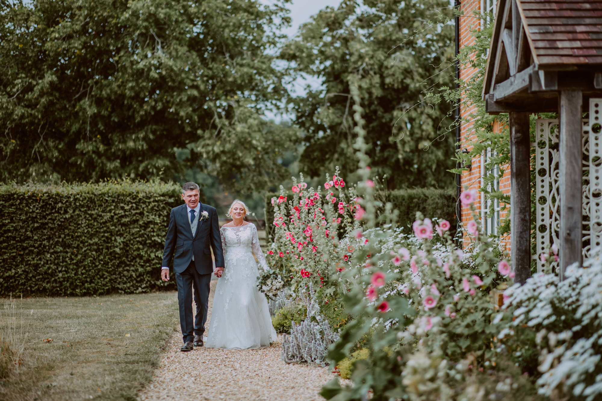 bride and groom walk hand in hand through the gardens at Primrose Hill Farm during their wedding photos
