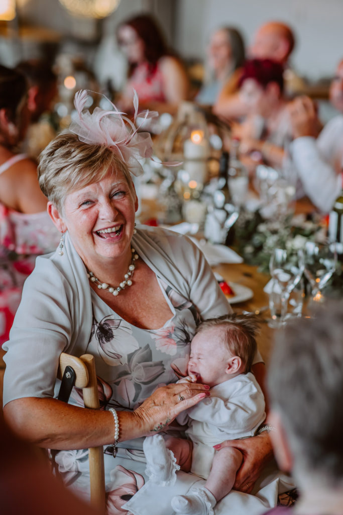 Lady holding a baby smiling into the camera