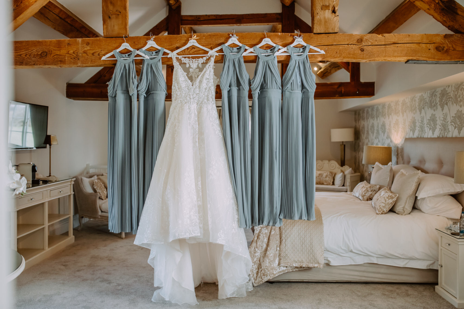 Bride and bridesmaids dresses hanging from the beam in the Theodore Suite