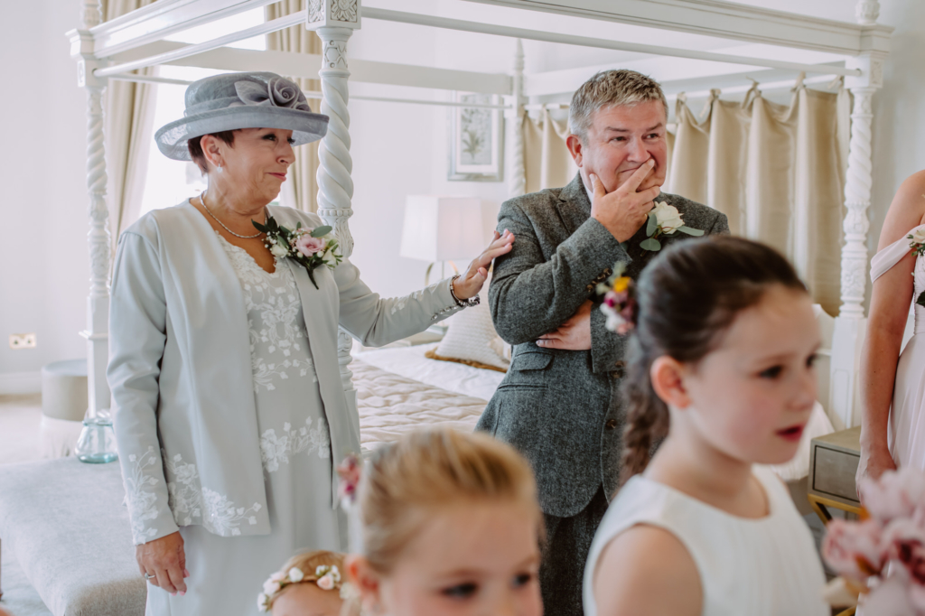 Bride's parents get emotion while admiring bride in her wedding dress