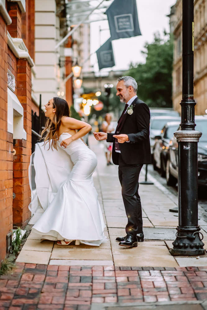 The bride and the groom dancing on the Church street as they hear the music music from the Hotel's bar