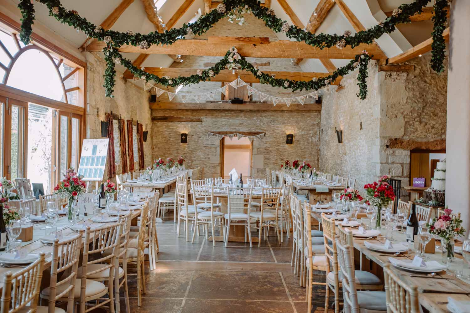 Oxleaze Barn wedding breakfast beautifully decorated main barn with flower decorations
