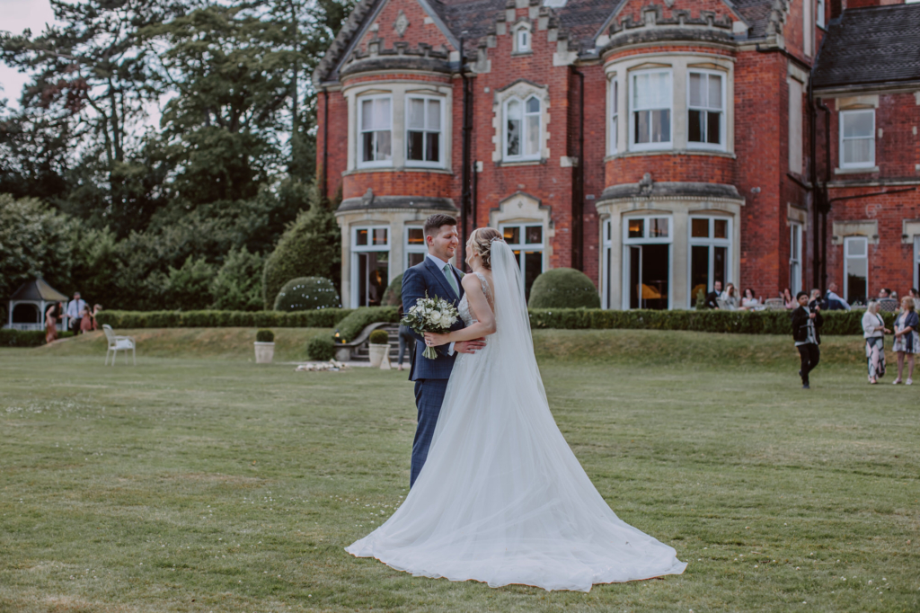 Pendrell Hall wedding photography. Bride and groom looking at each other and posing for portraits with the venue in the background