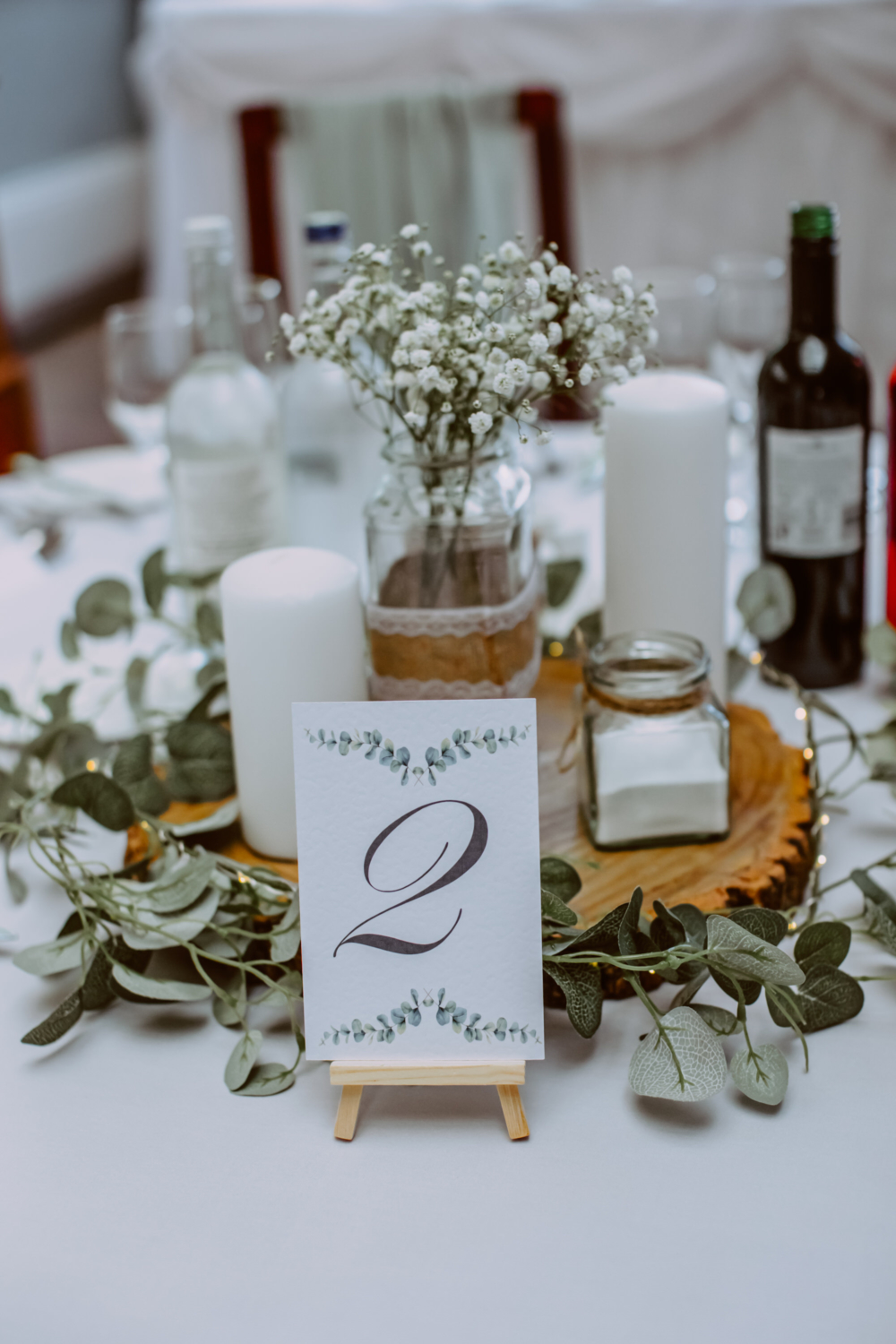 Detailed photo of decorated table with candles, table number and flowers