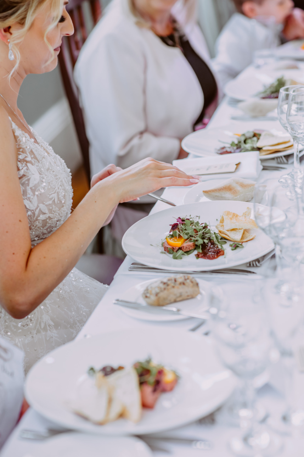 Bride sitting by the table with a starter infront of her looking at the menu