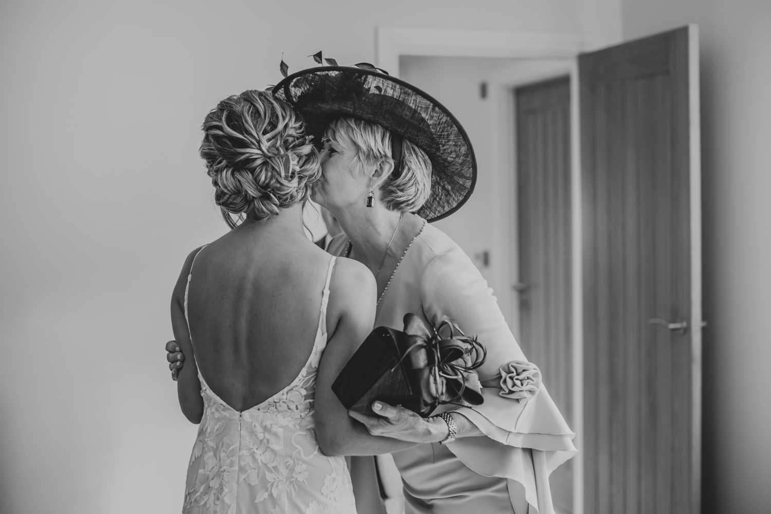 Mother of the bride kiss her daughter on the cheek before the ceremony starts