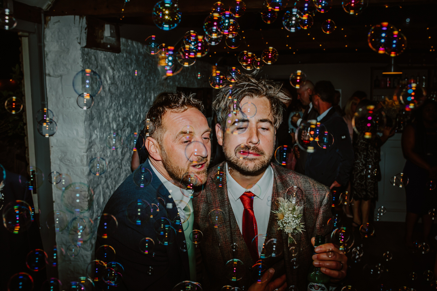 The groom and his friend enjoys the bubbles on the dance floor