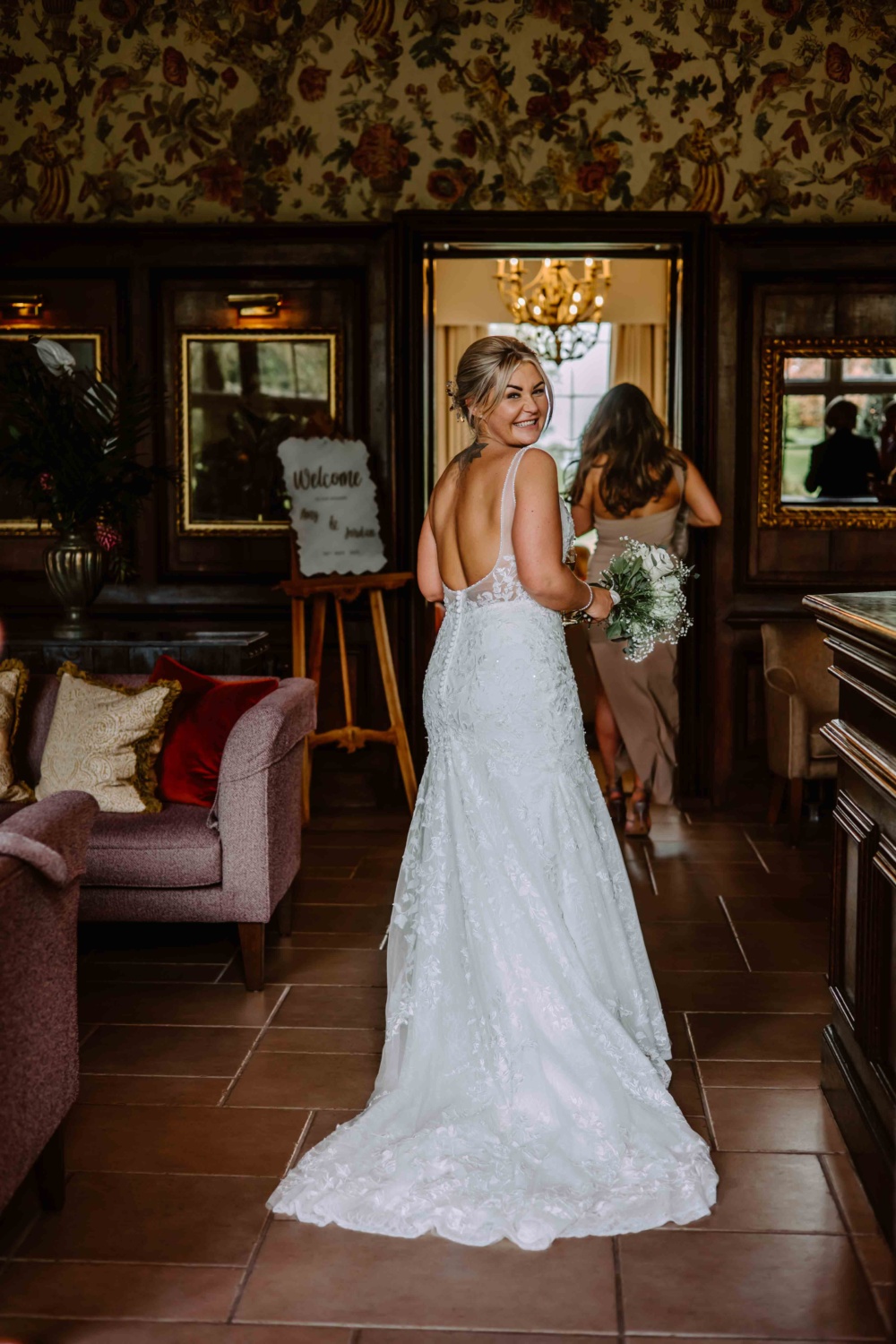 Bride happily glancing over her shoulder while walking in the entrance hall of Rowton Castle.
