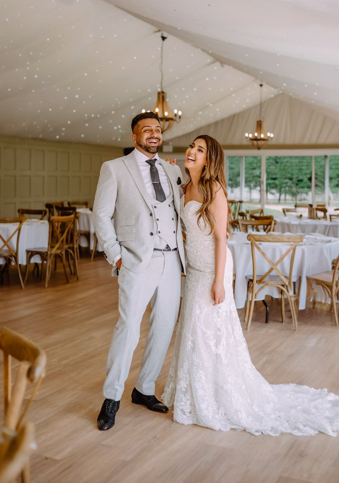 A bride and groom posing for a photo in a white marquee at Hogarths Hotel Solihull.