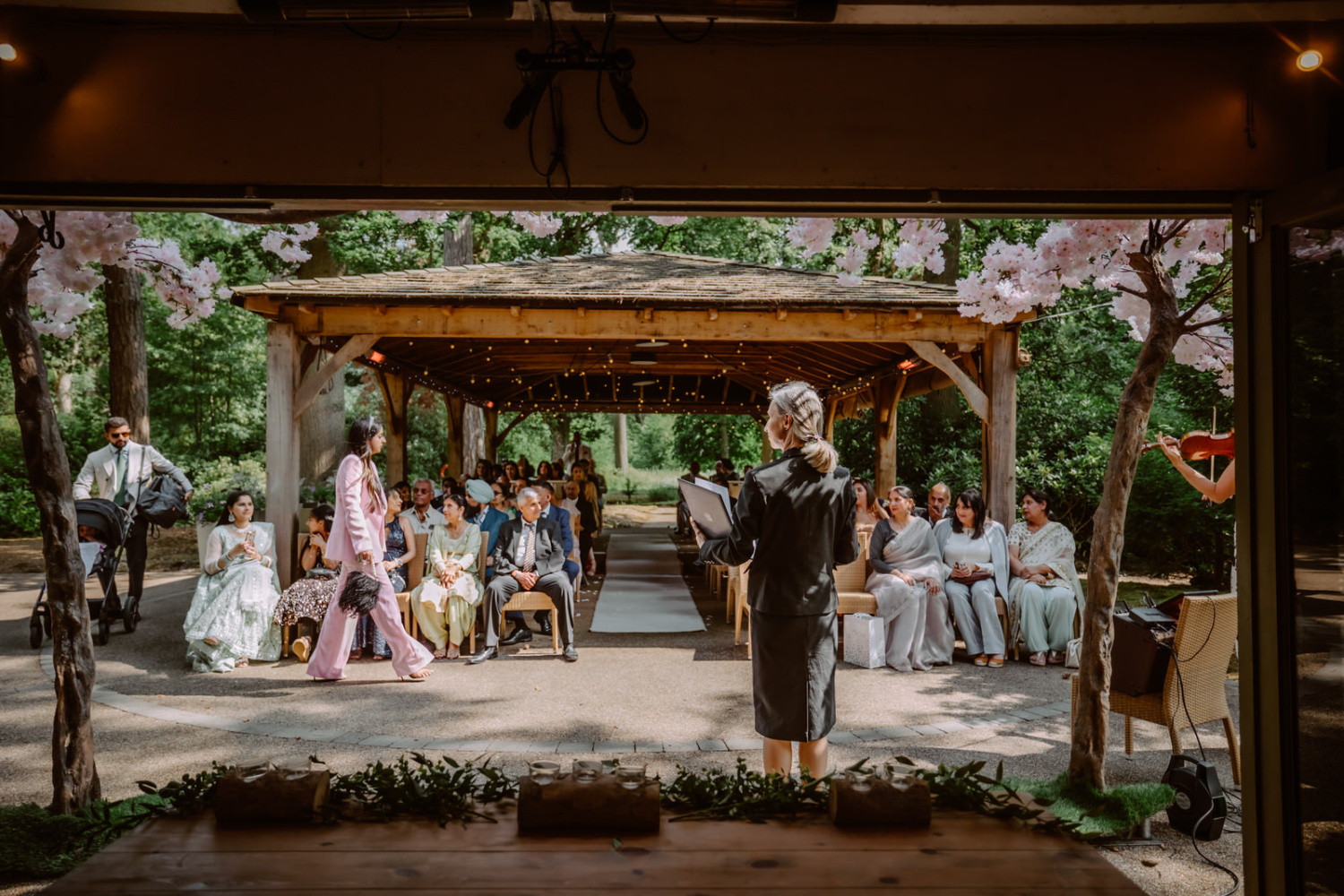 A wedding ceremony under a gazebo in a woods.