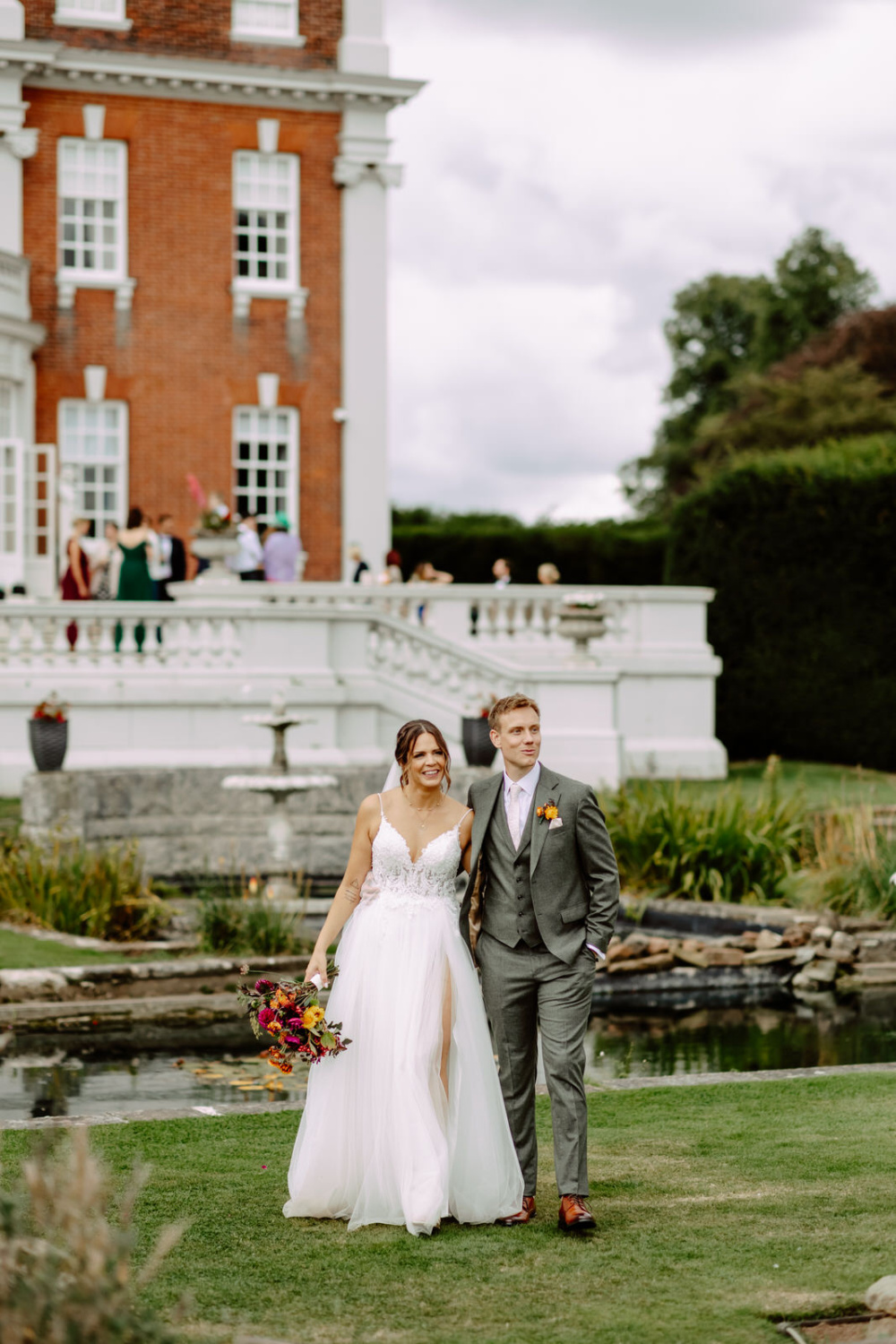 A bride and groom standing in front of the swinfen Hall.