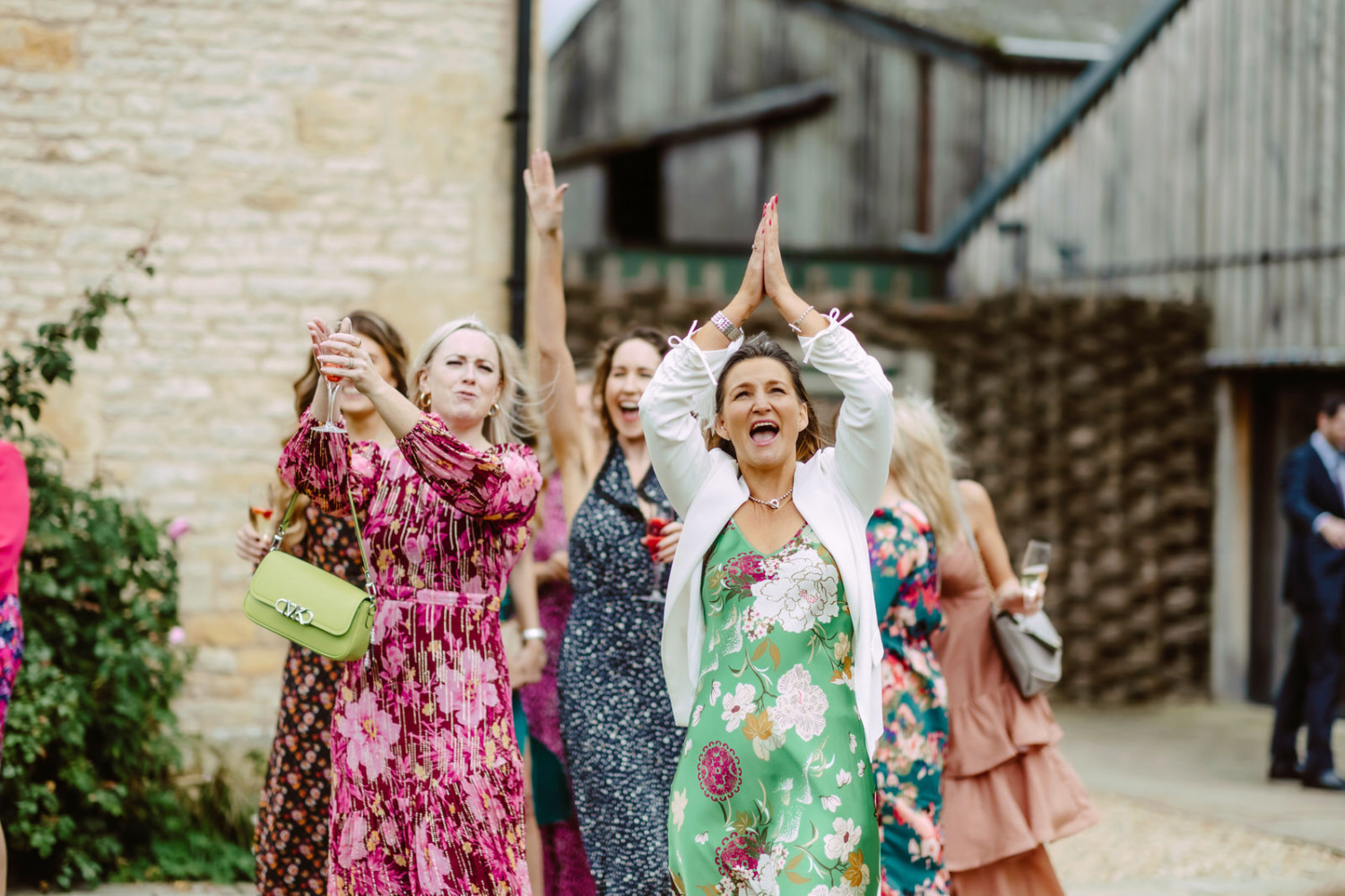 A group of bridesmaids waving their hands in the air.