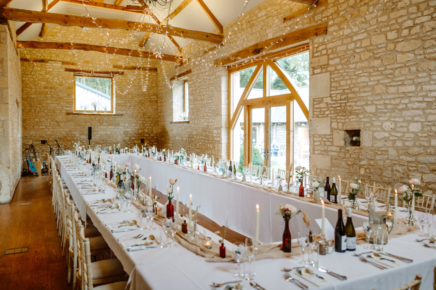 A long table set up in a stone barn for the wedding breakfast. 