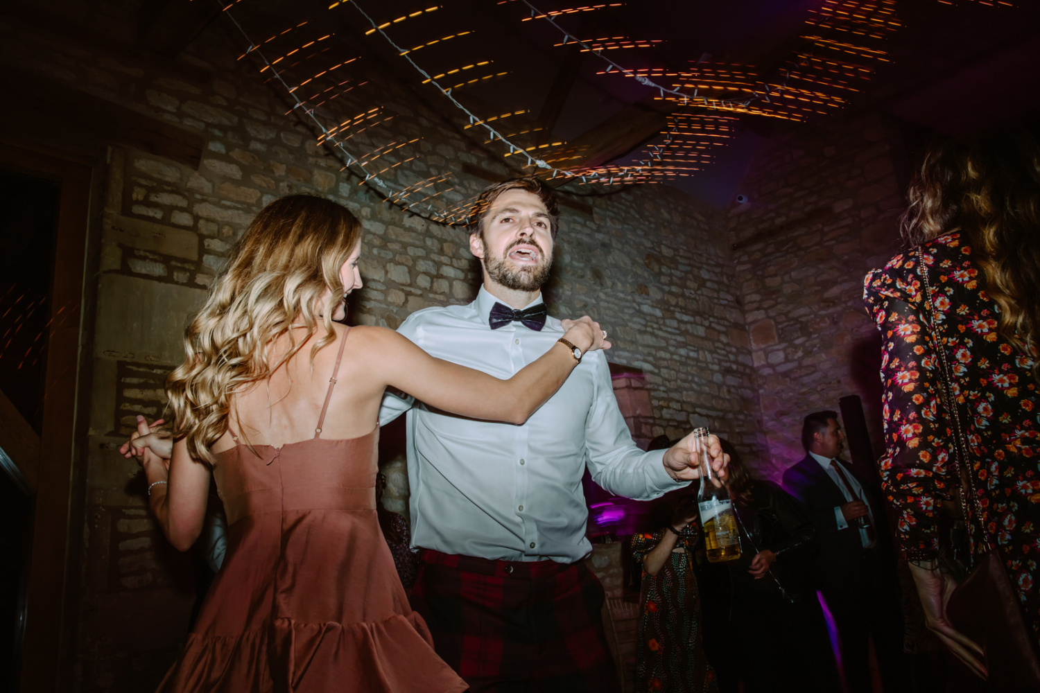 Wedding guests dancing on the dance floor at a party.