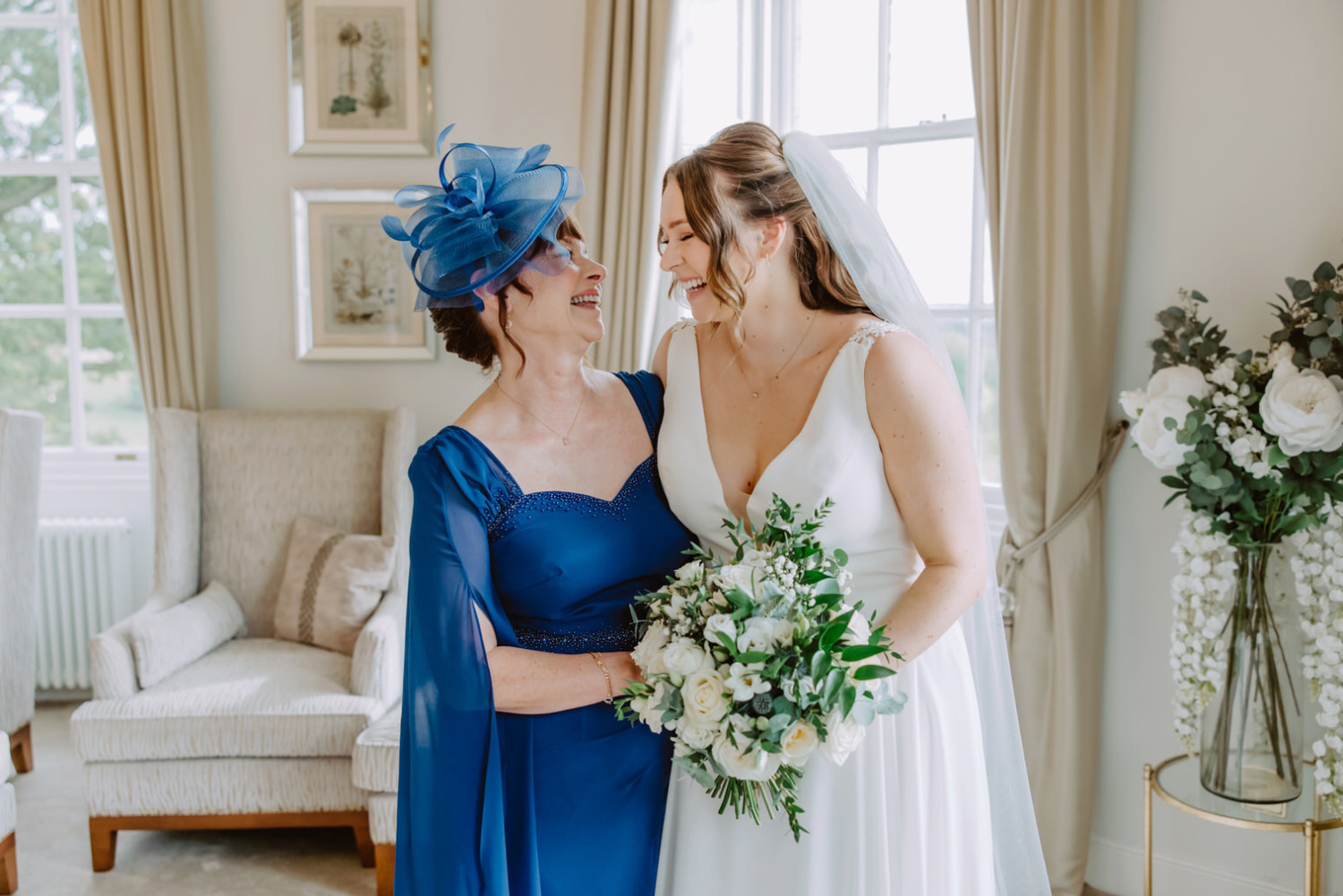 A bride and her mother in a blue dress.