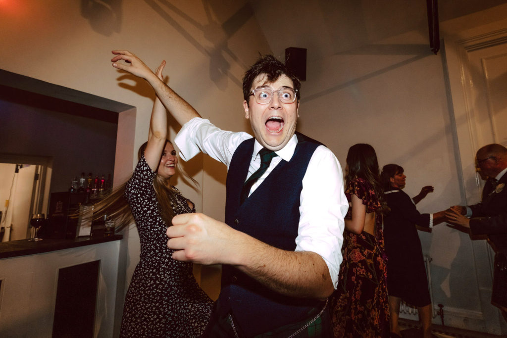 A man is dancing at a party with other people.