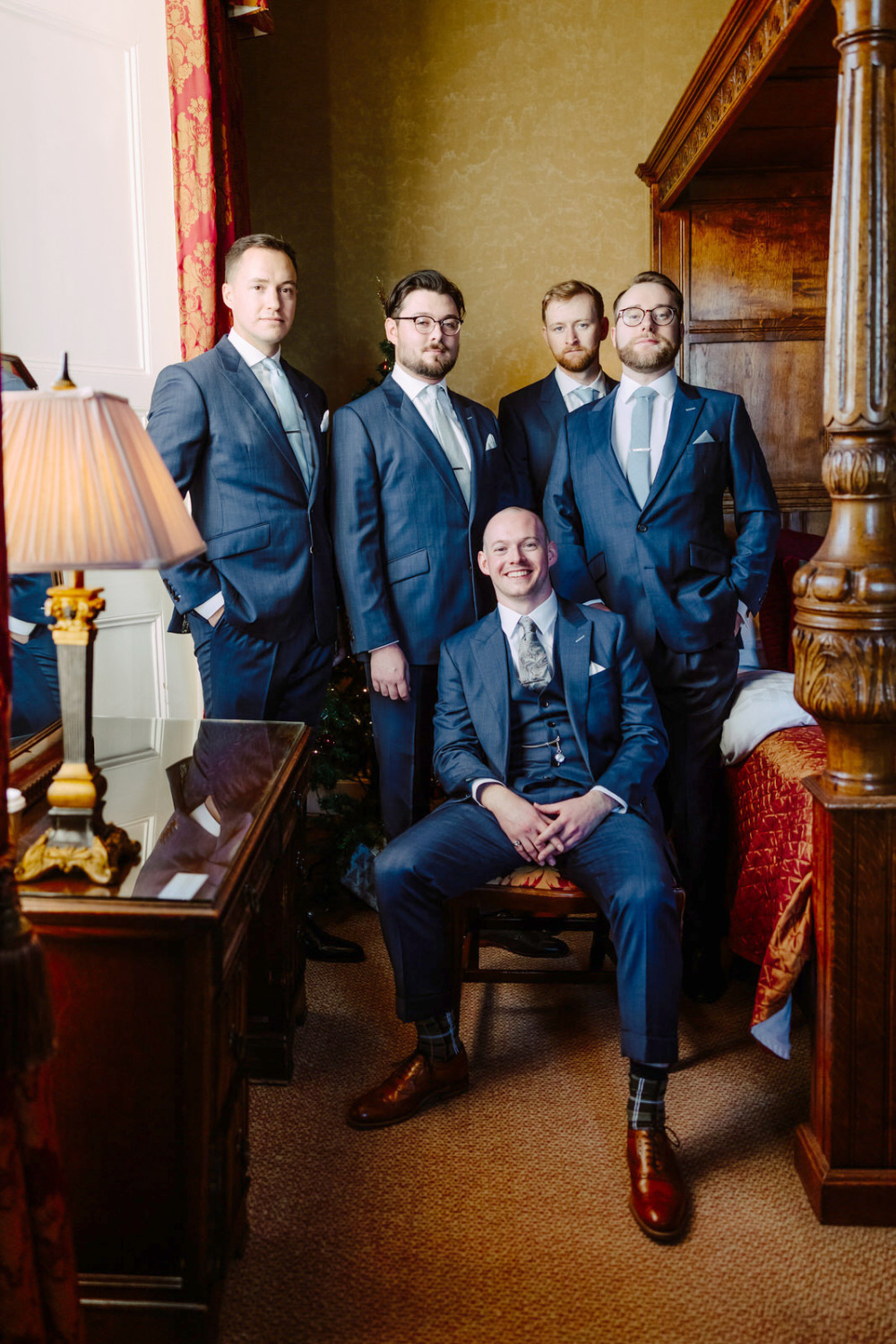 A group of groomsmen posing in a room at Rowton Castle.