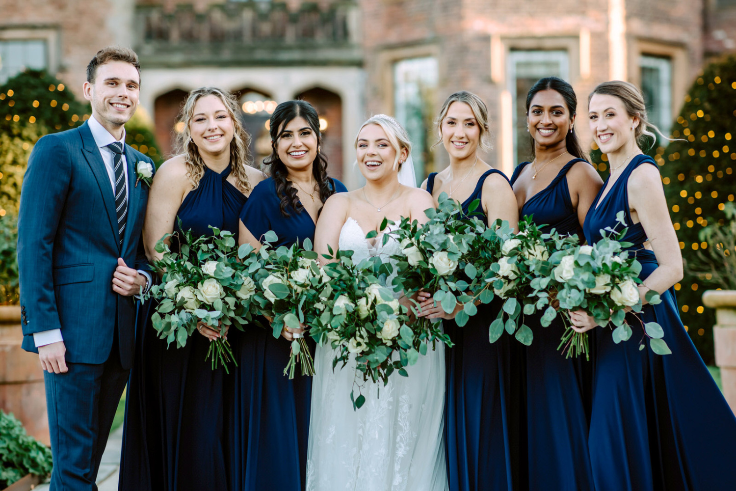 A group of bridesmaids and groomsmen pose for a photo at the wedding at Rowton Castle.