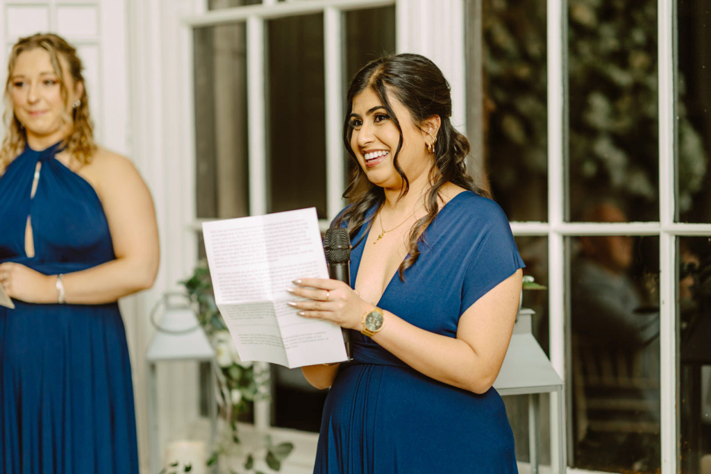 Two bridesmaids reading their vows at a wedding.
