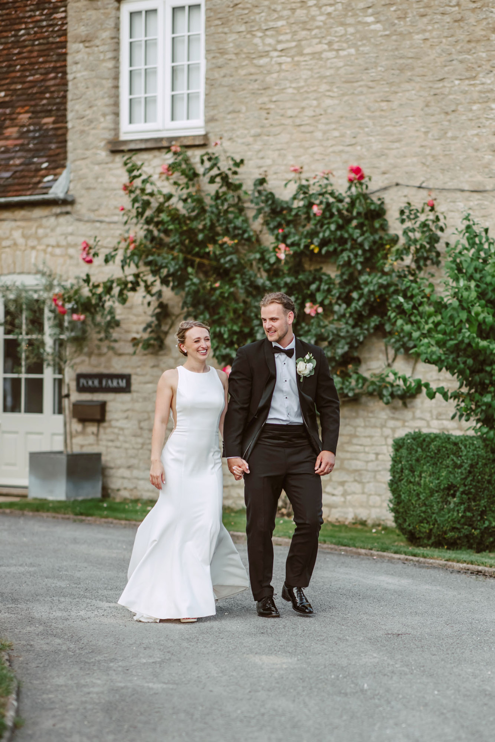 The bride and the groom walking hand in hand smiling et the Stratton court Barn