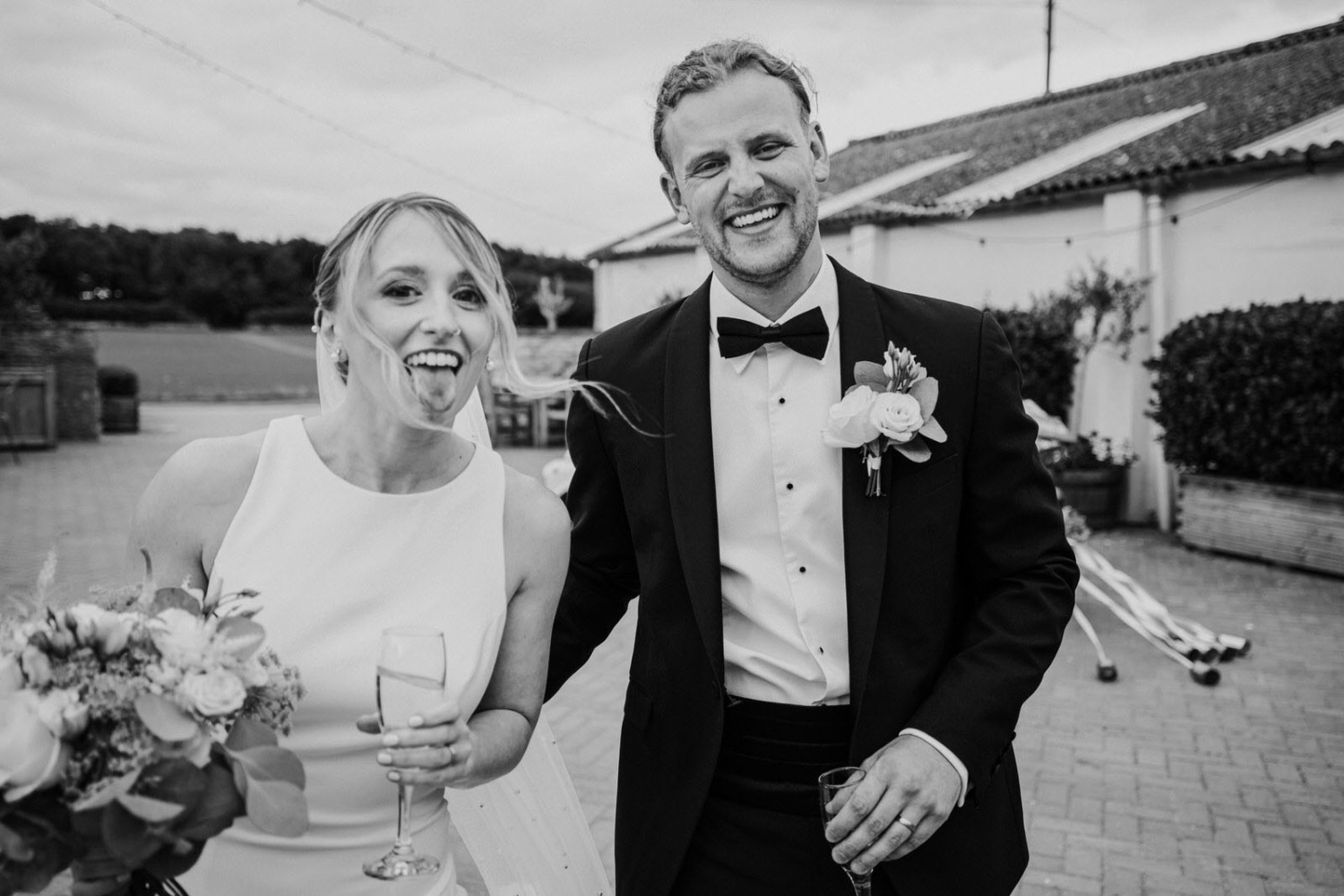 A black and white photo of a bride and groom laughing.