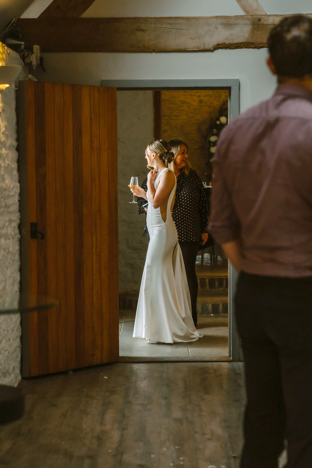 A bride and groom standing in the doorway of a barn.