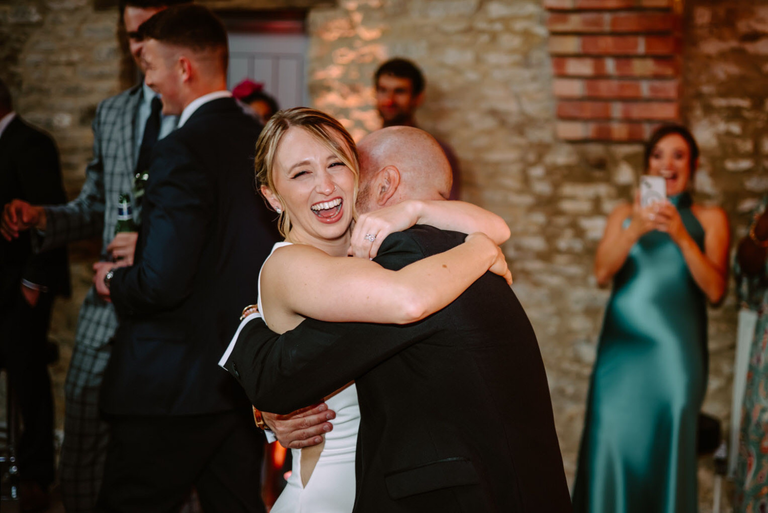 A bride and groom hugging at their wedding reception.