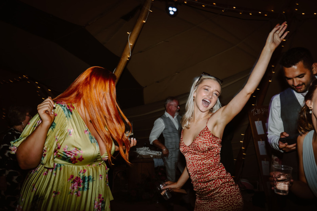 A group of people dancing at a party in a Tipi.