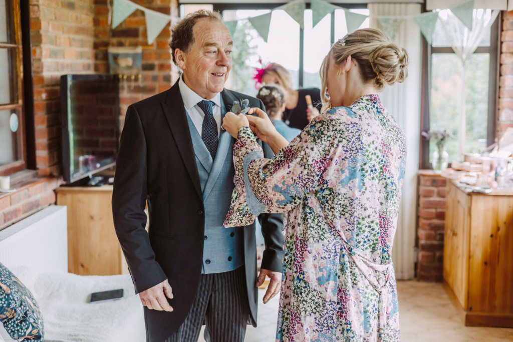 A bride putting on a dad's cufflinks.