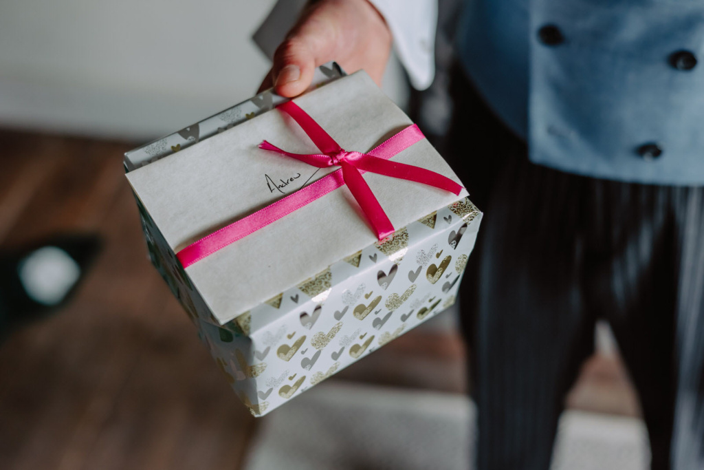 A man in a suit holding a gift box.