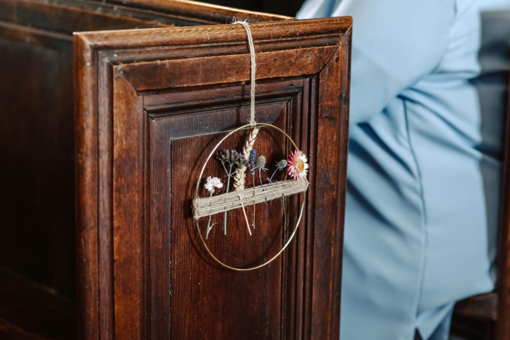 A woman is sitting in a wooden pew in a church.