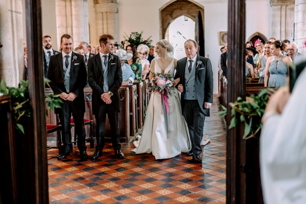 A bride and groom walking down the aisle in a church.