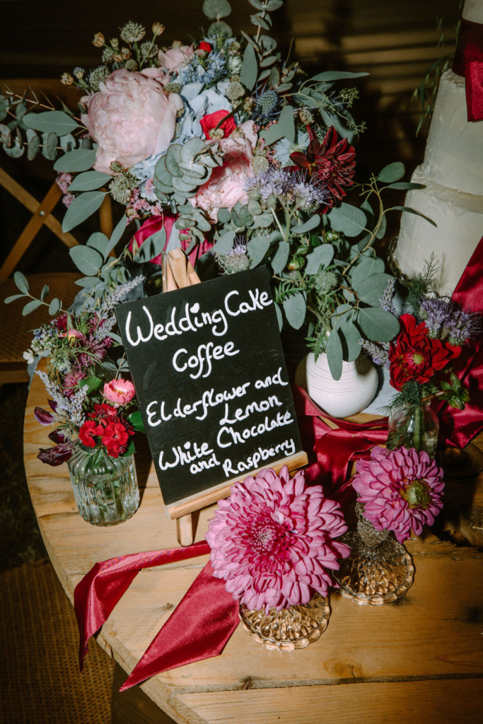 A table with flowers and a sign on it.