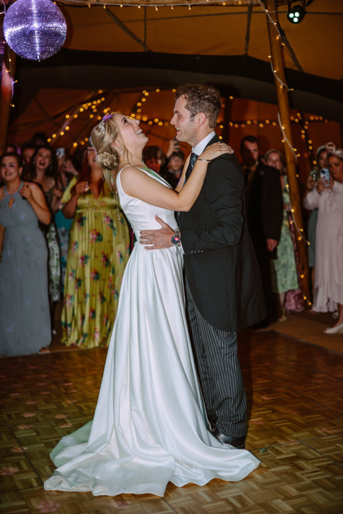 A bride and groom sharing their first dance in a Tipi.