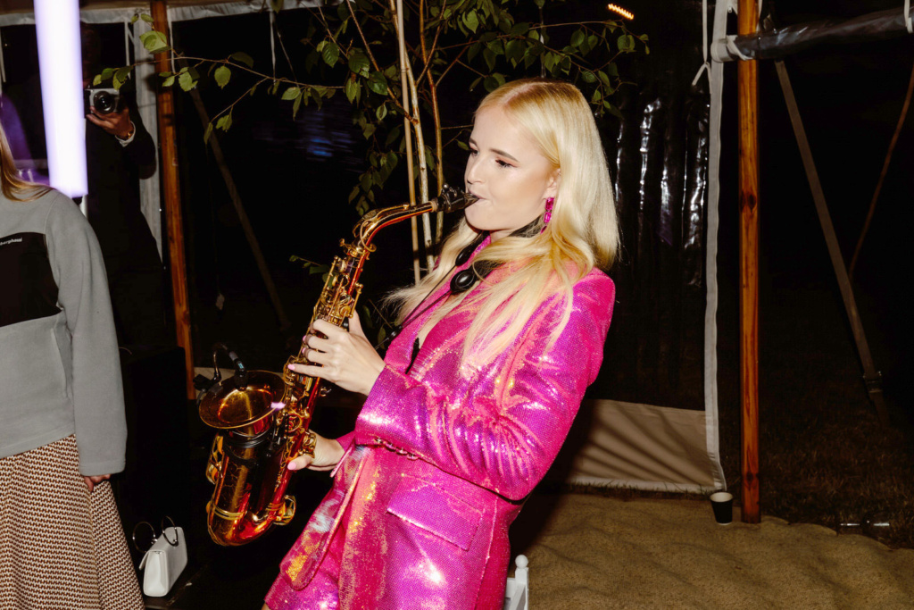 A blonde woman playing a saxophone.