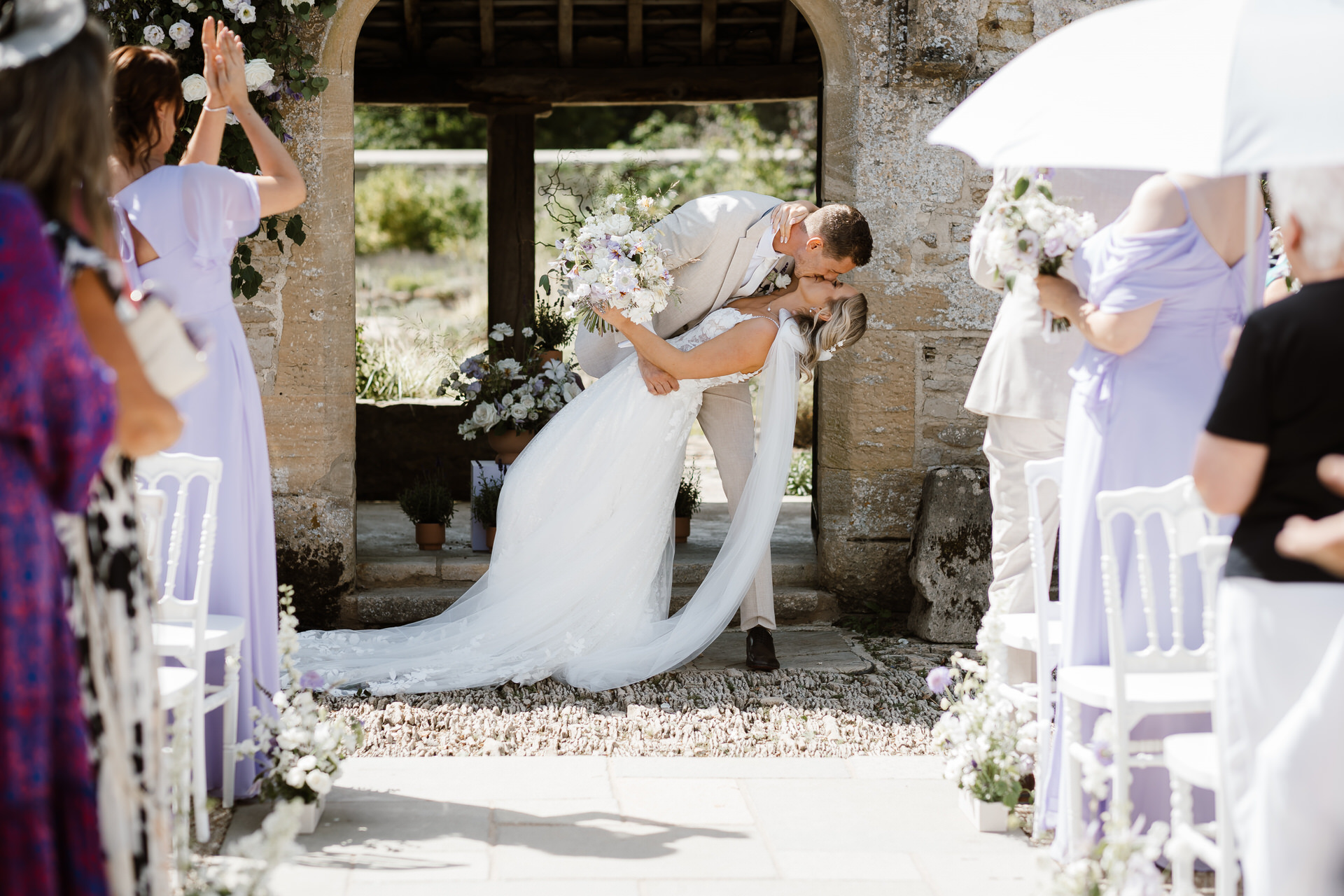 Caswell House wedding photographer. The bride and the groom's first kiss. Wedding gusts clapping.