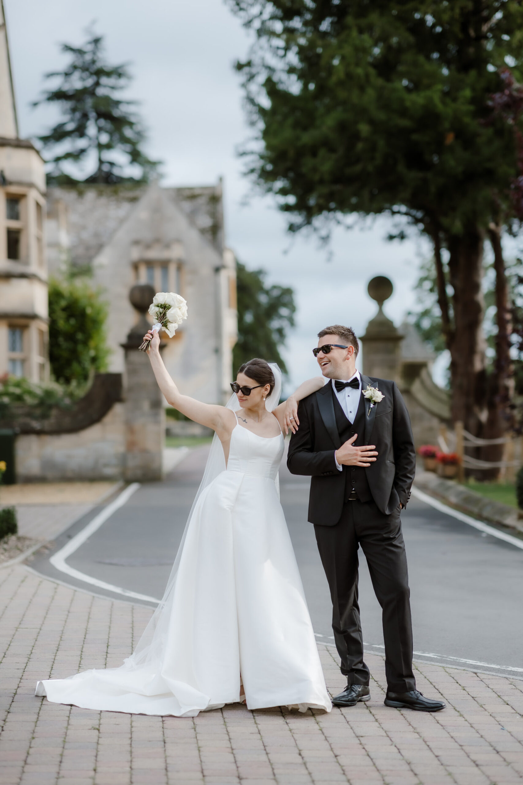 Ellenborough Park Wedding Photographer 81 As the bride joyfully walks while holding her bouquet, she passes a guest who is stunned by her beauty.